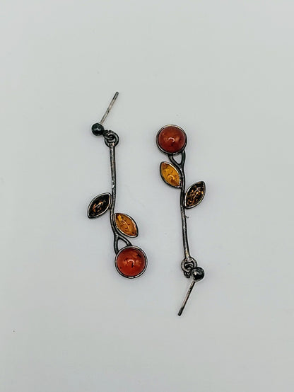 Pair of sterling silver vine earrings with round and marquise Baltic amber stones in three warm tones.