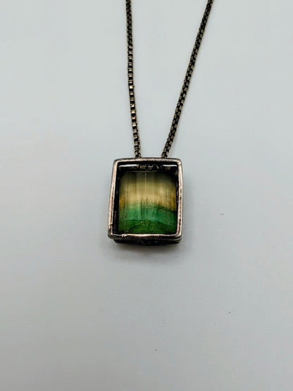 Sterling silver necklace featuring a rectangular bezel-set fluorite stone that fades from honey yellow to mossy green, hanging from an 18-inch box chain