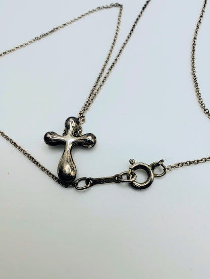 Sterling silver Tiffany & Co. Elsa Peretti teardrop cross pendant hanging from a delicate silver chain.