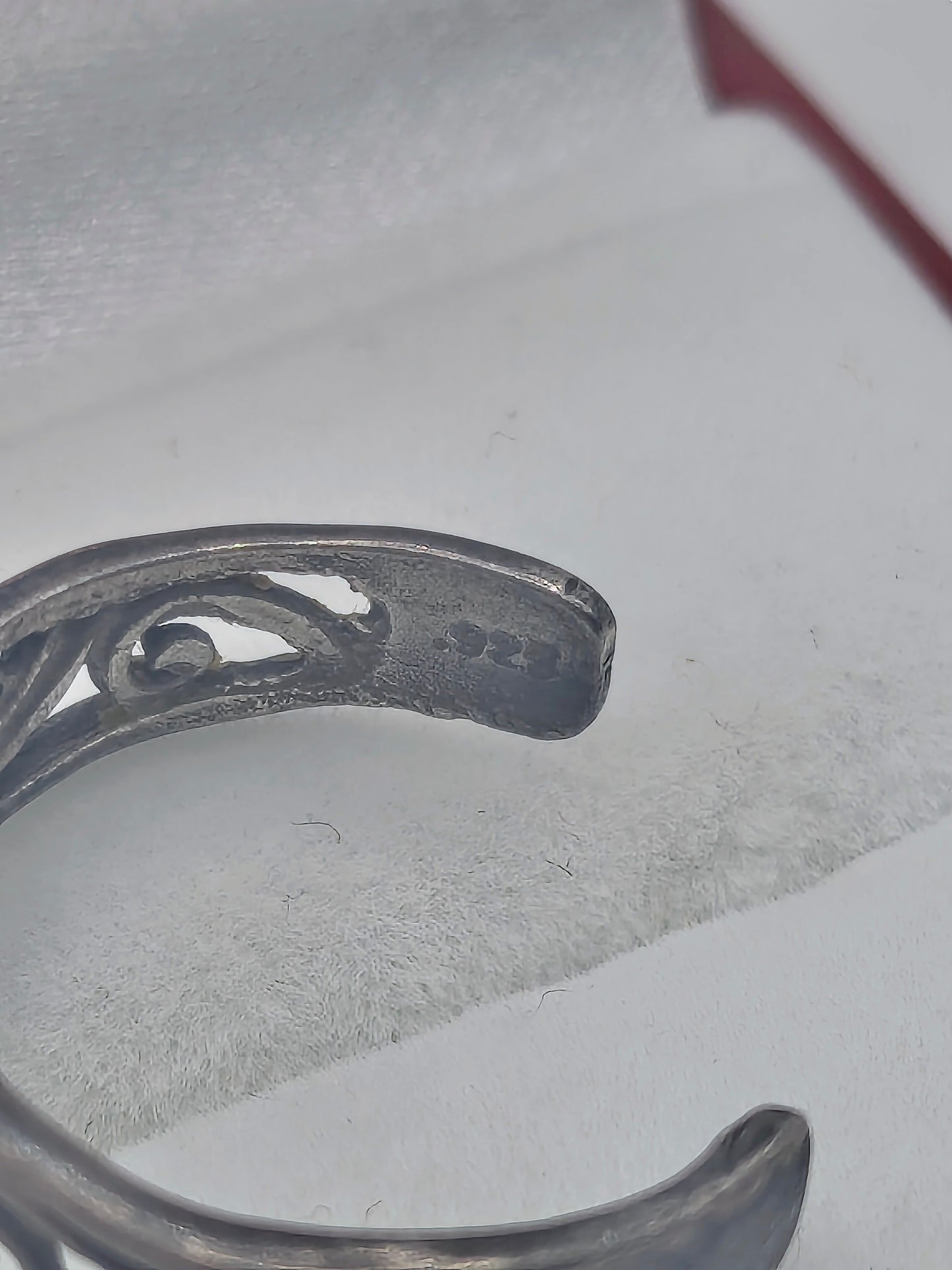 Sterling silver open floral filigree ring with dark patina, adjustable band displayed in a red and white ring box.