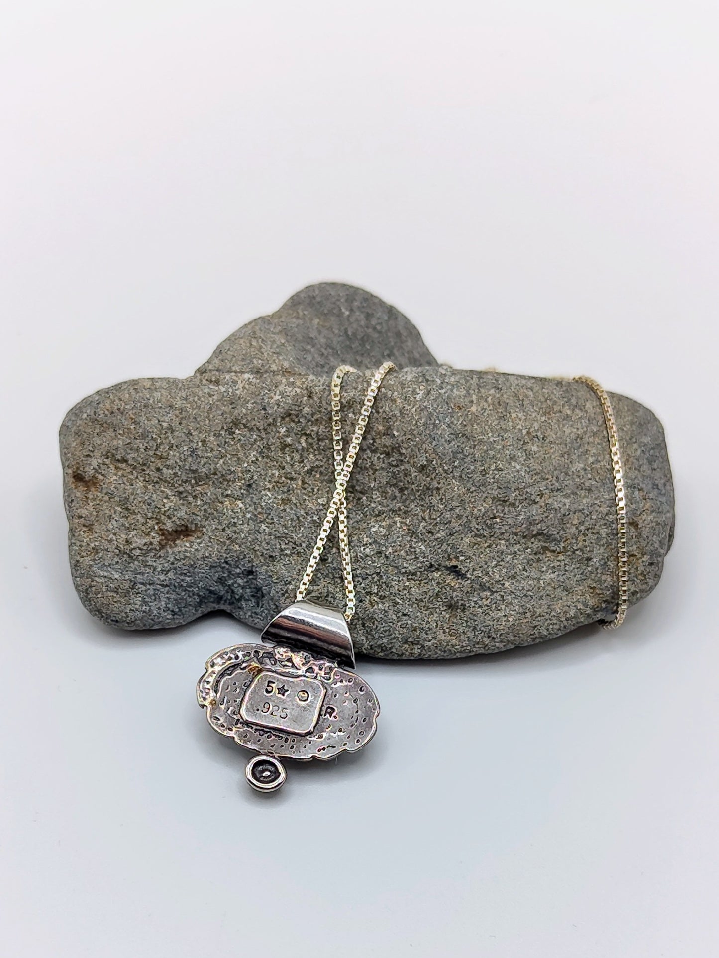 Back of the Oracle Stone Necklace pendant showing the 5 star 925 R hallmark on textured sterling silver.