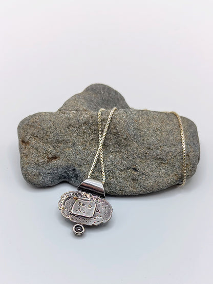 Back of the Oracle Stone Necklace pendant showing the 5 star 925 R hallmark on textured sterling silver.