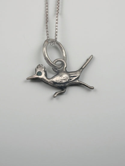 Sterling silver roadrunner pendant necklace with a tiny turquoise eye on a box chain, shown on a clean white background.