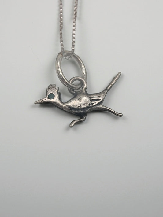 Sterling silver roadrunner pendant necklace with a tiny turquoise eye on a box chain, shown on a clean white background.