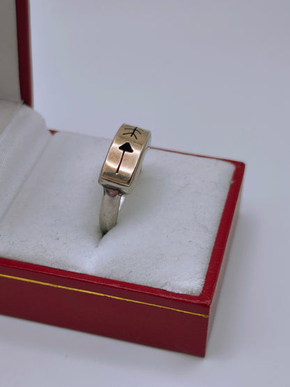 Sterling silver and 14k gold ring featuring an engraved arrow and feather design, displayed in a red and white ring box.