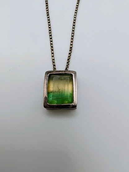 Sterling silver necklace featuring a rectangular bezel-set fluorite stone that fades from honey yellow to mossy green, hanging from an 18-inch box chain
