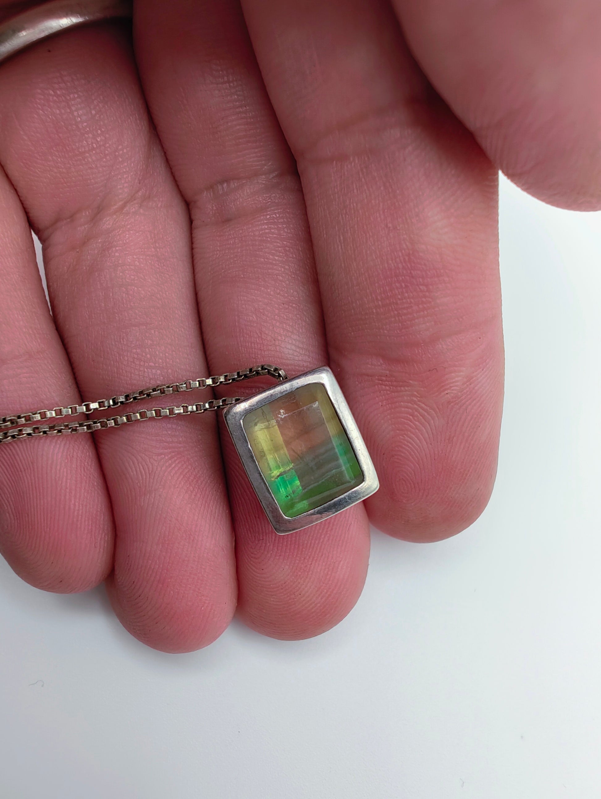 Sterling silver necklace featuring a rectangular bezel-set fluorite stone that fades from honey yellow to mossy green, hanging from an 18-inch box chain