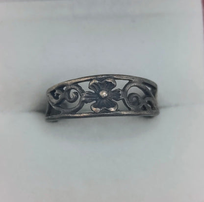 Sterling silver open floral filigree ring with dark patina, adjustable band displayed with a white background