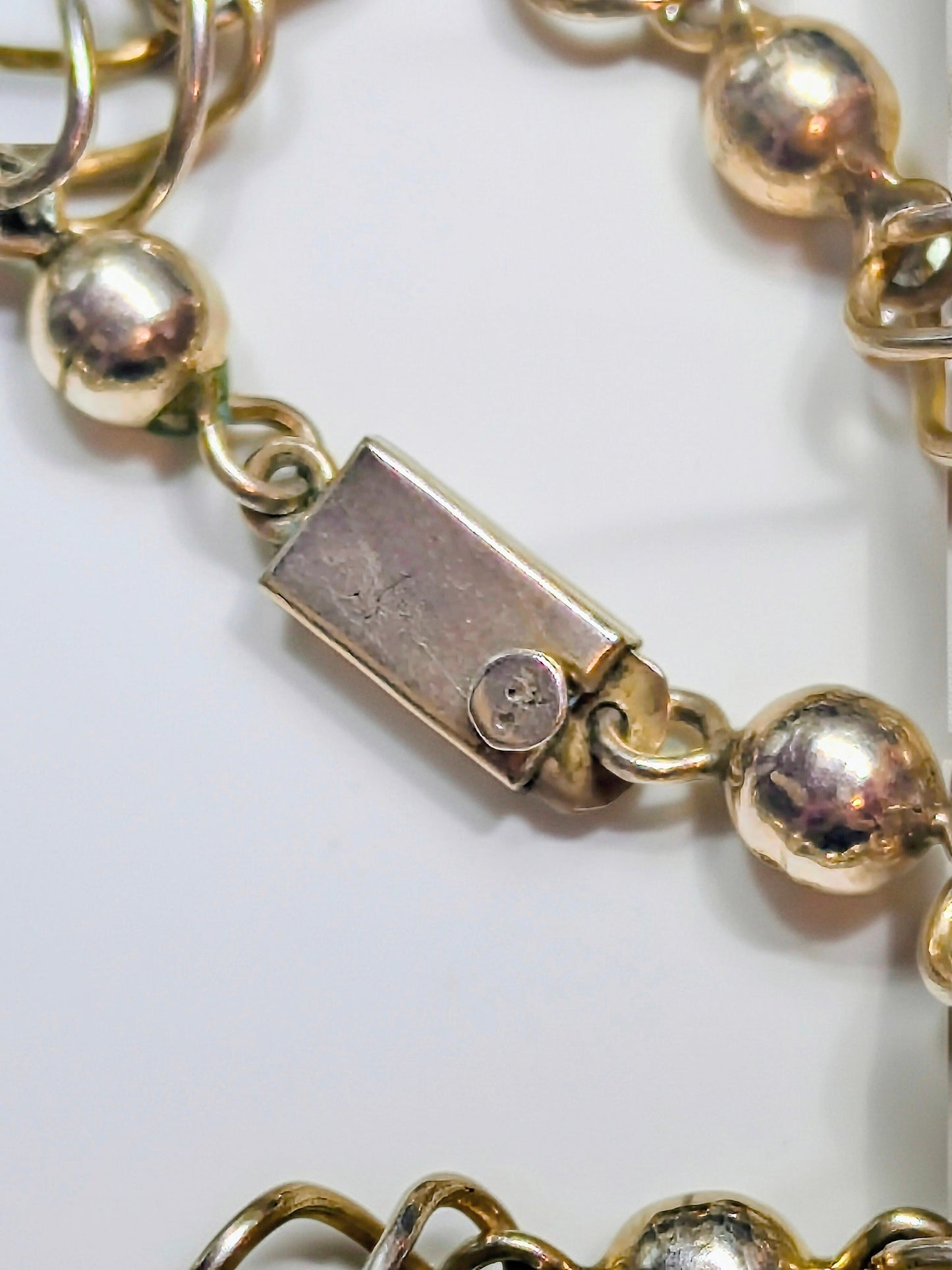 Sterling silver necklace composed of polished round beads alternating with open spiral-cage links.