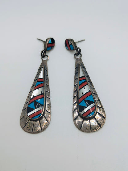 Pair of long sterling silver teardrop dangle earrings with geometric inlay of turquoise, coral, onyx, and mother-of-pearl.