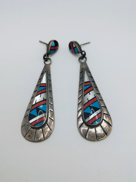 Pair of long sterling silver teardrop dangle earrings with geometric inlay of turquoise, coral, onyx, and mother-of-pearl.