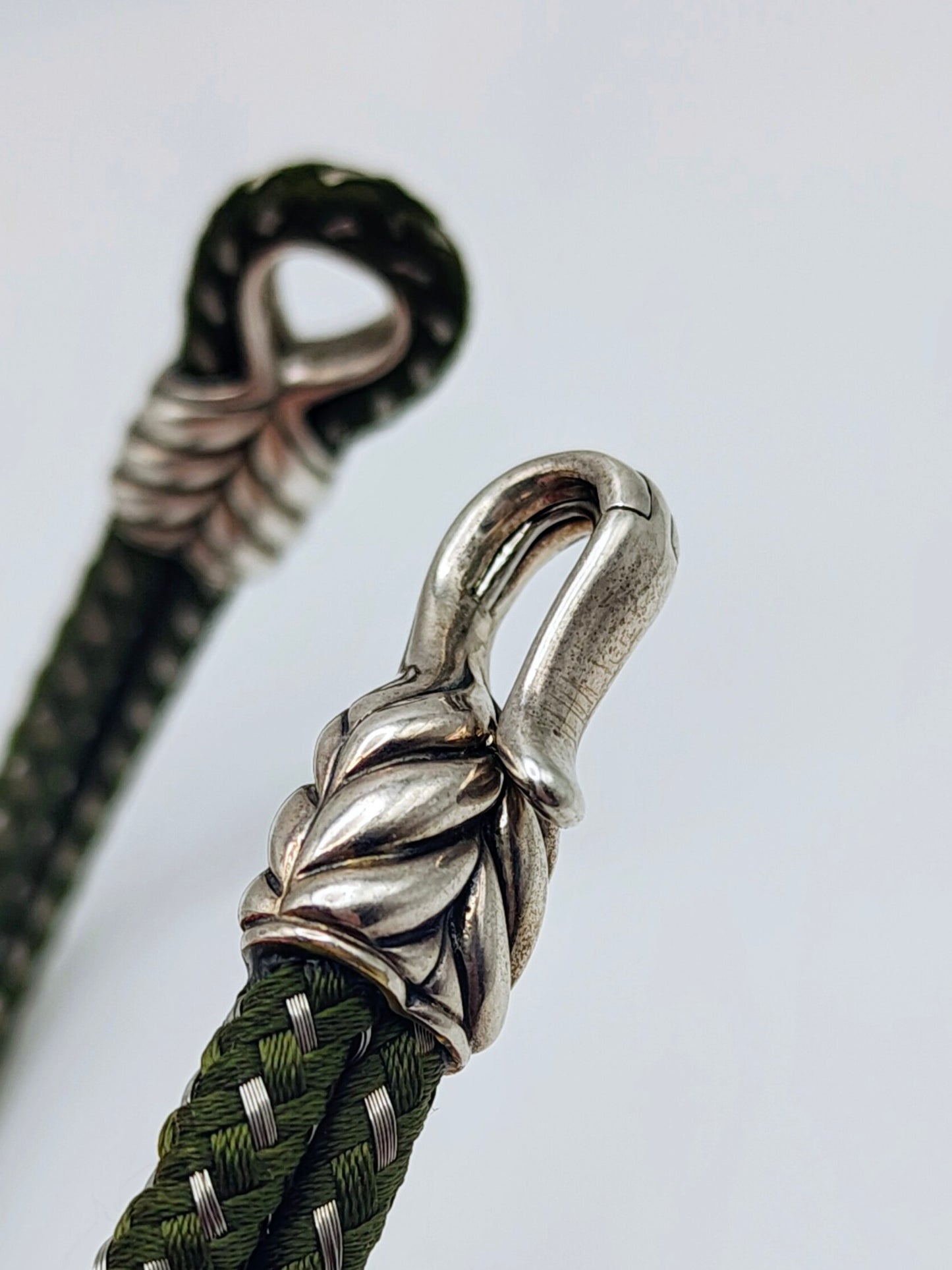 Dark forest-green braided cord bracelet with sculpted sterling silver end caps and a hook clasp, designed by David Yurman.