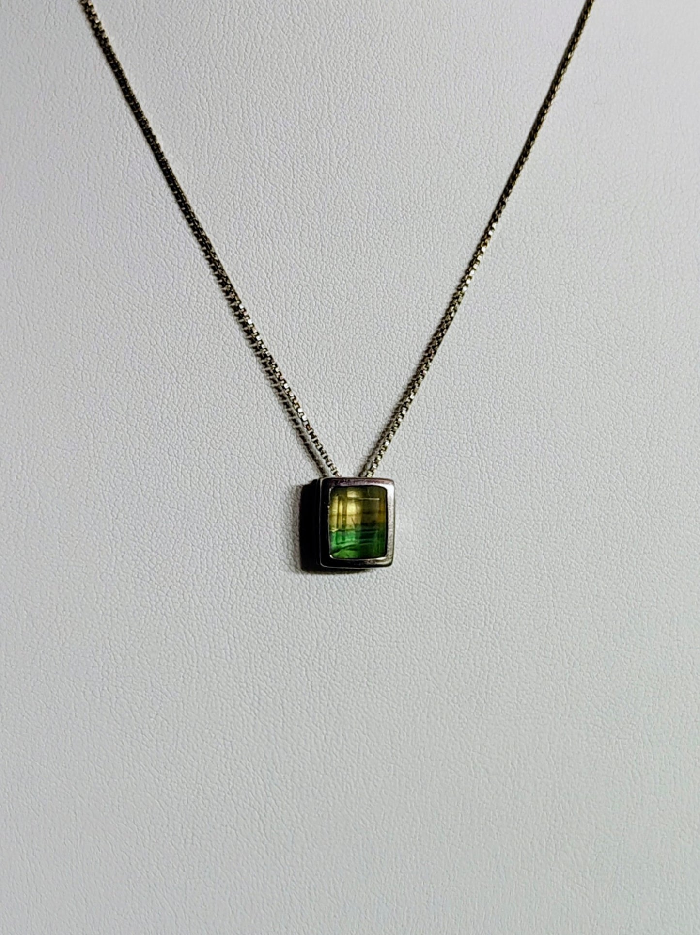 Sterling silver necklace featuring a rectangular bezel-set fluorite stone that fades from honey yellow to mossy green, hanging from an 18-inch box chain