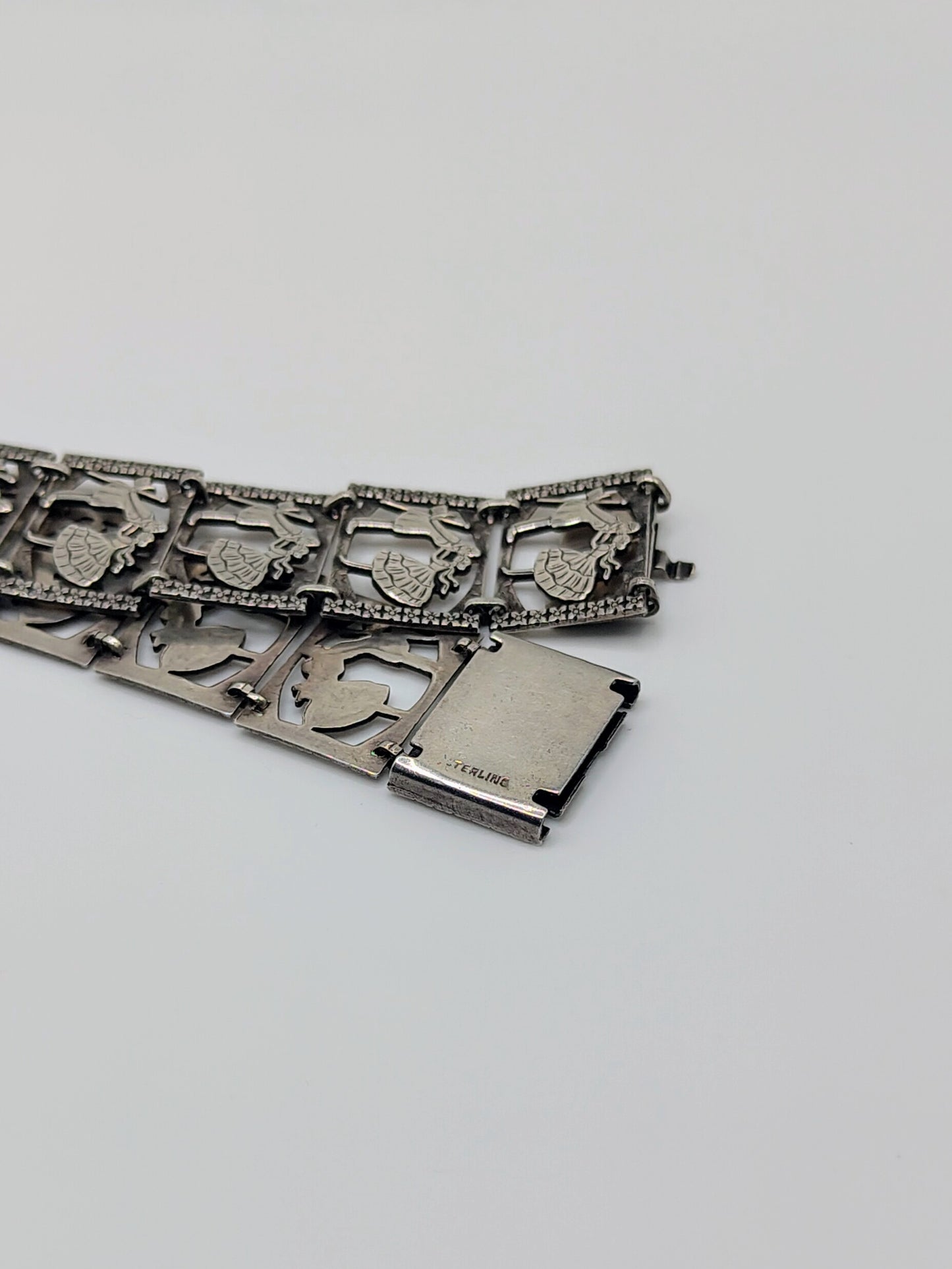 Sterling silver panel bracelet with raised dancing couple designs.