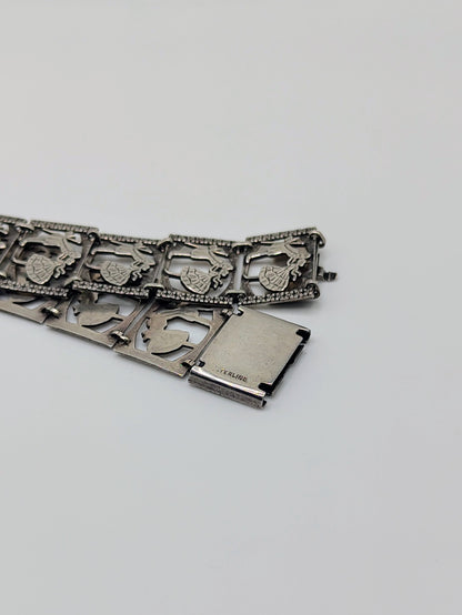 Sterling silver panel bracelet with raised dancing couple designs.