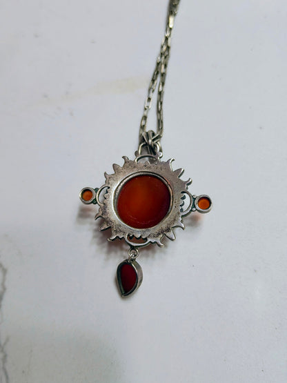 Sterling silver pendant necklace with a domed carnelian stone, two small side carnelian cabochons, and a dangling teardrop