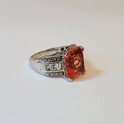 Side view of the Spinel Sunlight Ring showing an emerald-cut orange spinel set in sterling silver with diamond-accents