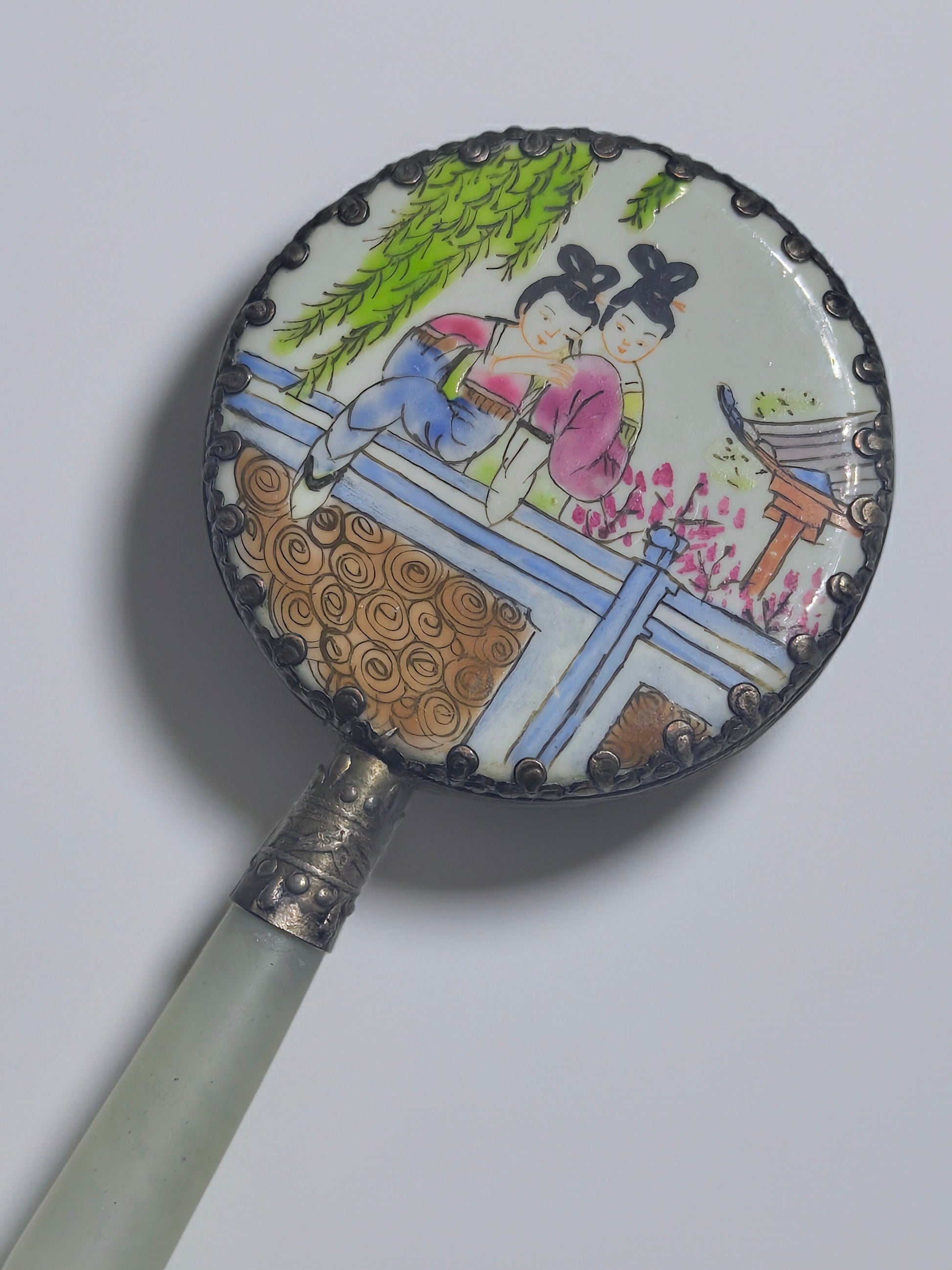 Vintage Chinese jadeite hand mirror shows a painted porcelain scene of two figures under willow branches, in sterling silver.