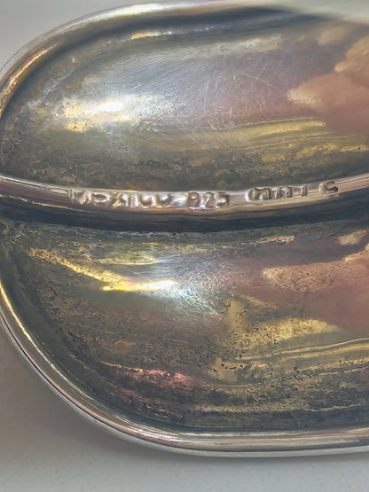 Close up view of solid sterling silver horizon-band cuff bracelet with smooth, minimal profile, displaying the markings.