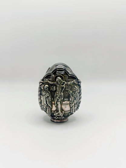 Palm-sized fine silver egg from Greece, richly carved with raised religious icon scenes and darkened recesses.