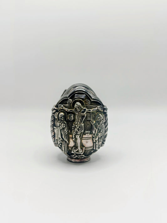 Palm-sized fine silver egg from Greece, richly carved with raised religious icon scenes and darkened recesses.