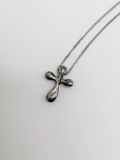 Sterling silver Tiffany & Co. Elsa Peretti teardrop cross pendant hanging from a delicate silver chain.