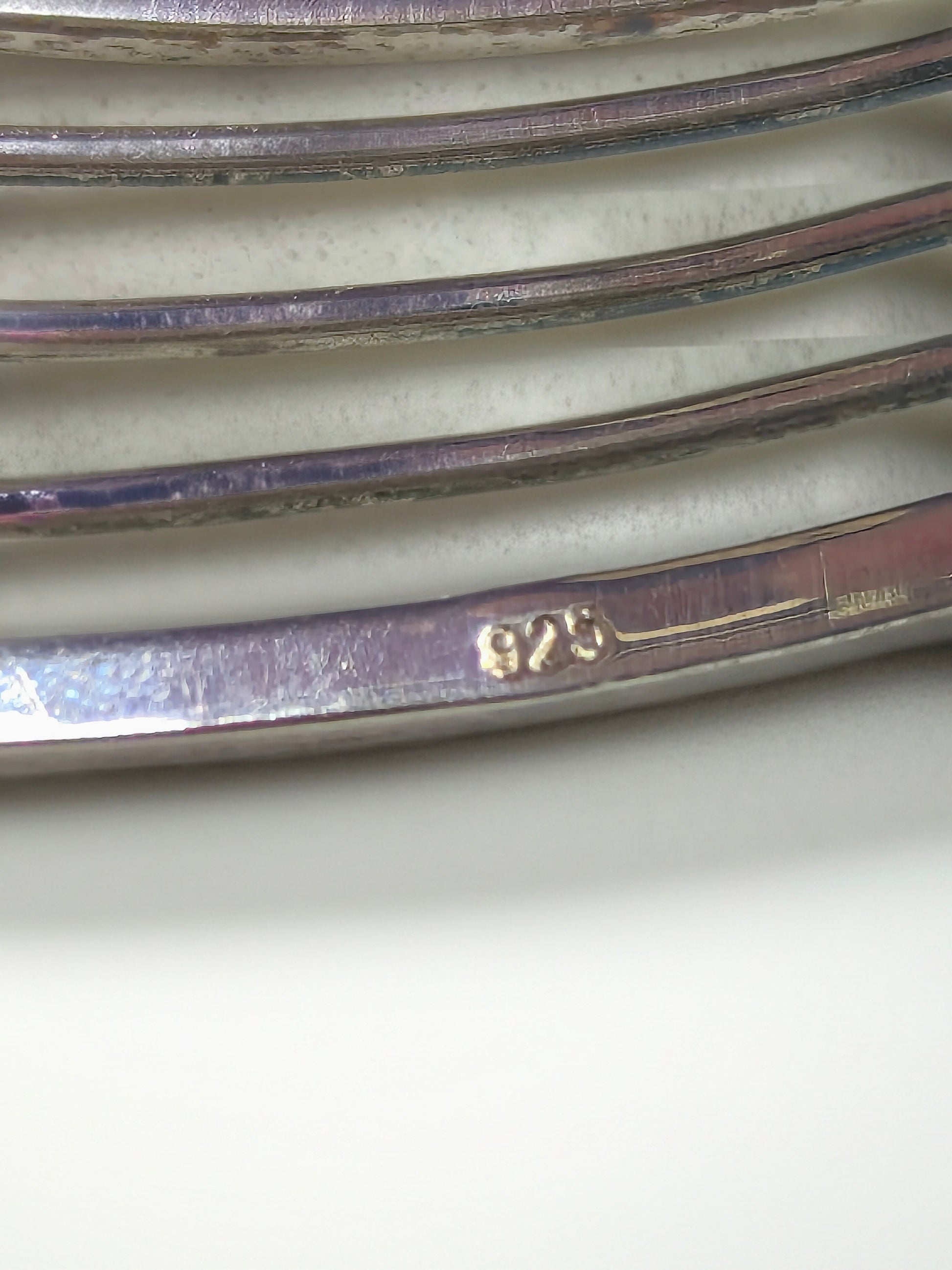 Close-up of the inside of the Abacus of Thresholds sterling silver cuff showing the 925 hallmark on the metal.