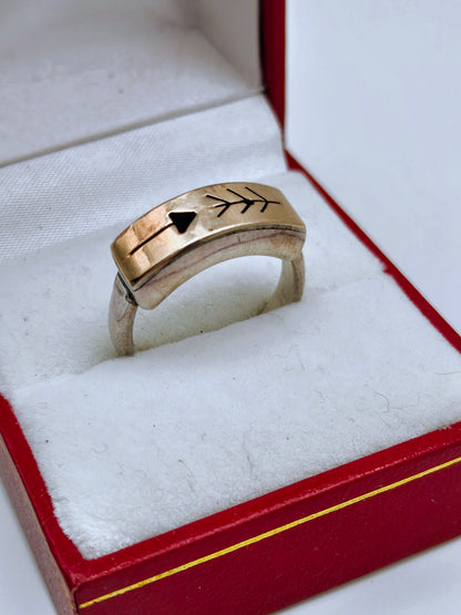 Sterling silver and 14k gold ring featuring an engraved arrow and feather design, displayed in a red and white ring box.
