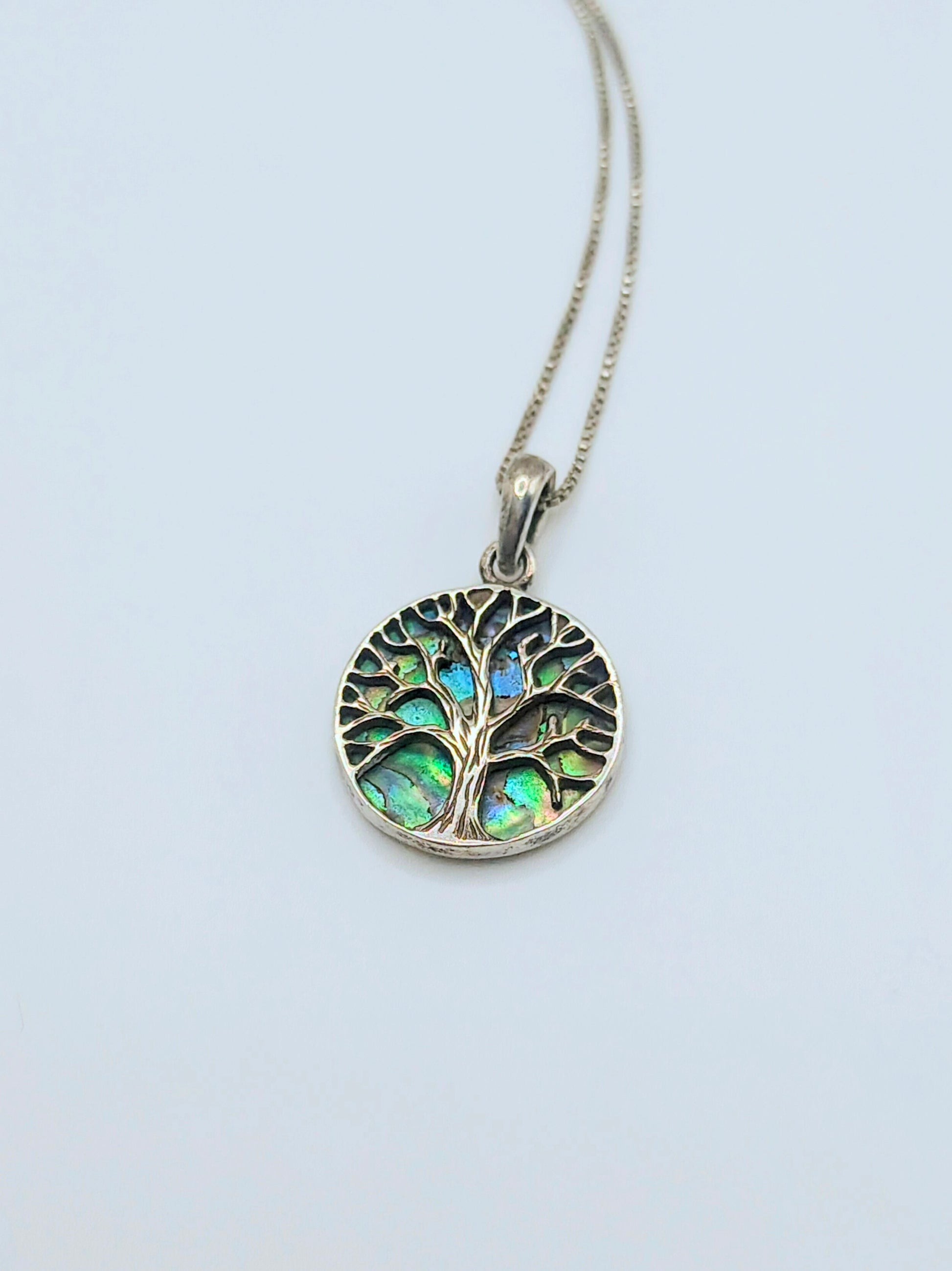 Sterling silver Tree of Life pendant with iridescent green and blue abalone shell inlay, with a delicate silver box chain.