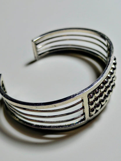 Sterling silver Abacus of Thresholds cuff bracelet with rows of movable silver beads on parallel bars.