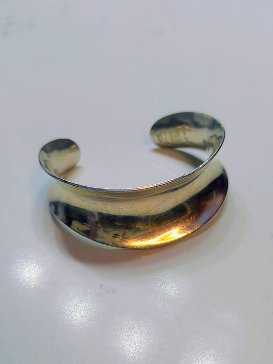 Wide vintage Mexican sterling silver bone-style cuff bracelet with curved shape on a white background.