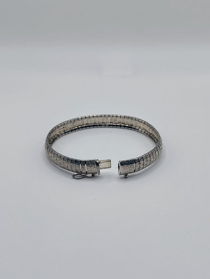 Silver Omega Bracelet opened at the hinged box clasp, displaying the interior links and safety latch.