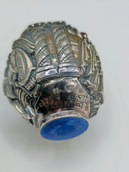 Palm-sized fine silver egg from Greece, richly carved with raised religious icon scenes and darkened recesses.