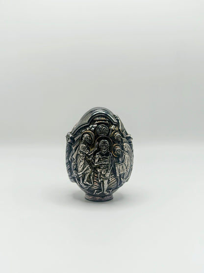 Palm-sized fine silver egg from Greece, richly carved with raised religious icon scenes and darkened recesses.